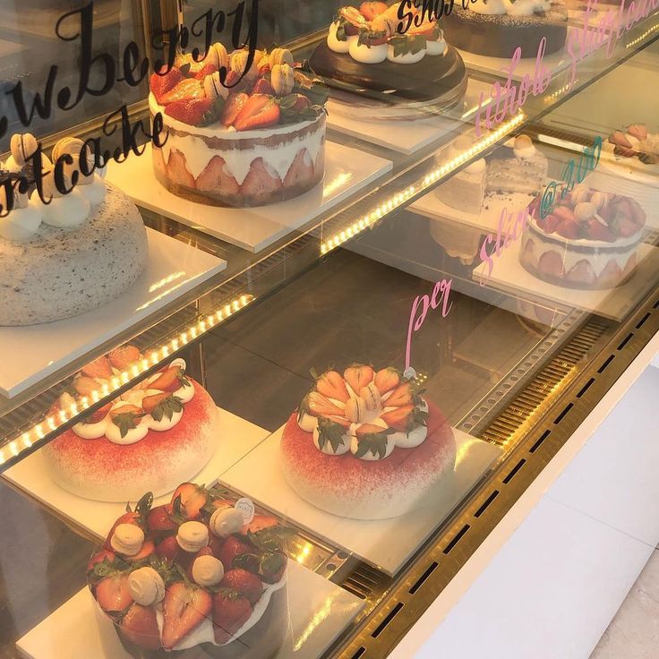 Assorted decorated cakes displayed in a glass bakery case
