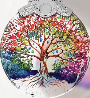 Colorful tree of life design on a round glass ornament with multicolored leaves and roots