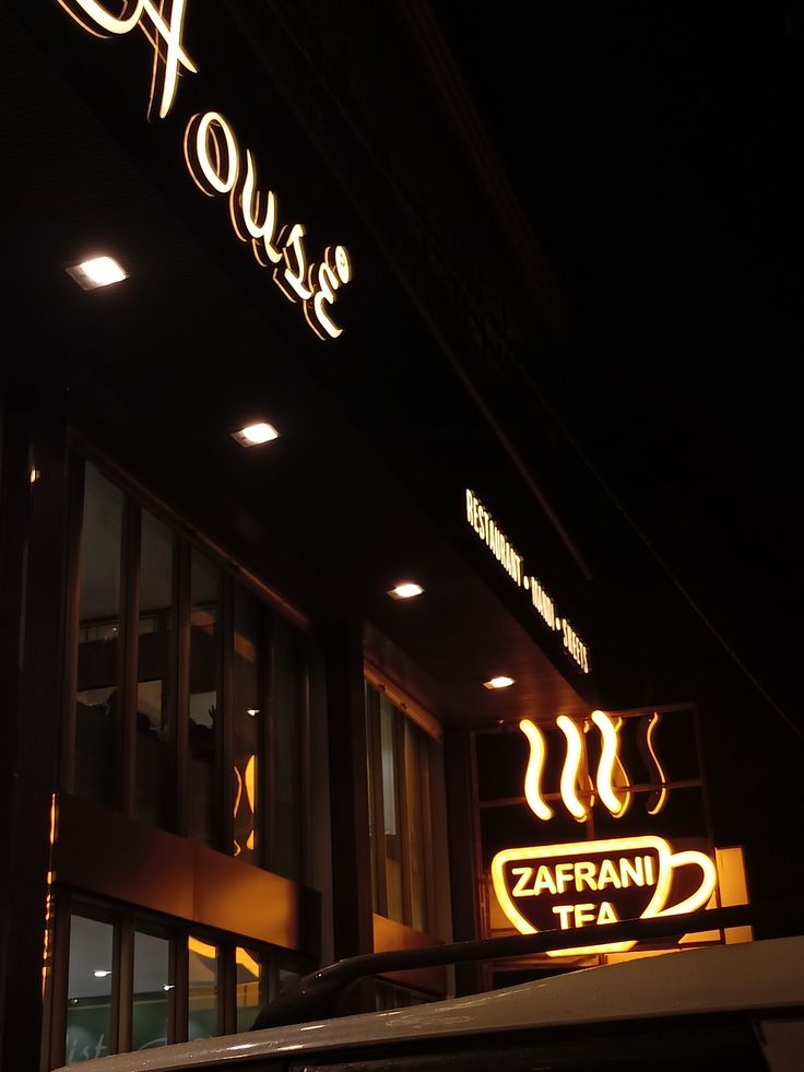 Illuminated coffee house facade on a dark street at night