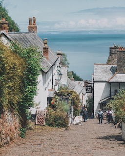 Steep cobbled street lined with white cottages overlooking the sea