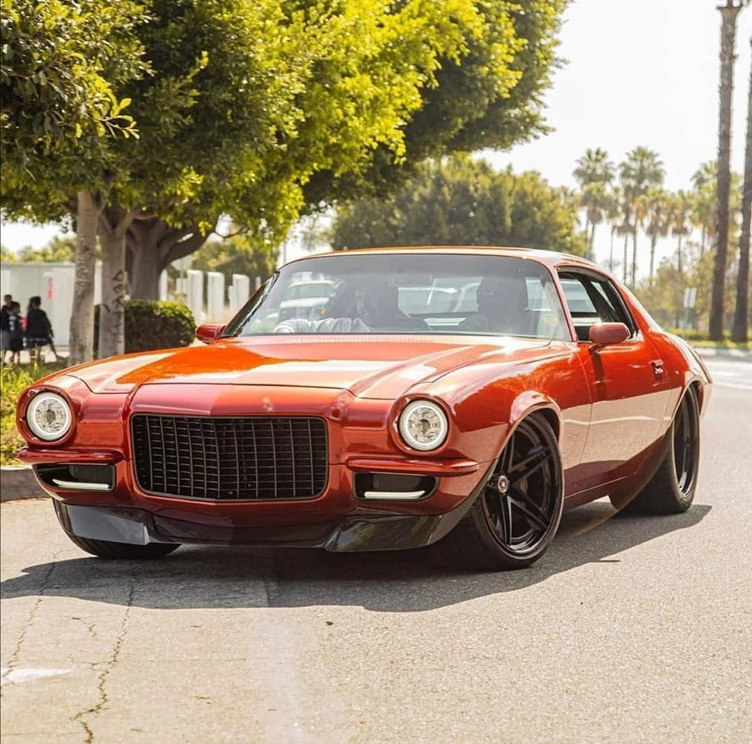 Orange classic Chevrolet Camaro SS parked on a sunny street, front view