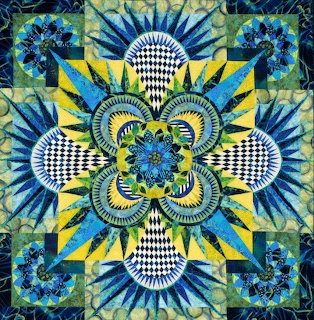Symmetrical floral mandala quilt in blue, green and yellow with checkered patterns