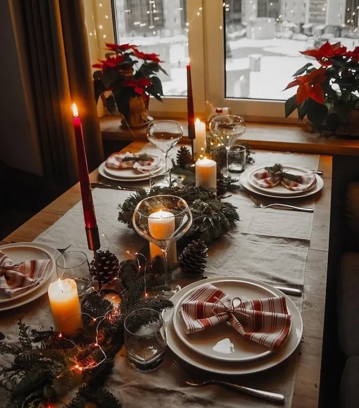 Christmas table setting with candles and holiday decorations