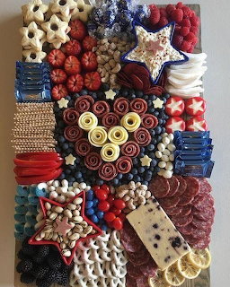 Festive dessert board with red, white and blue treats, star cookies, berries and candies in patriotic arrangement