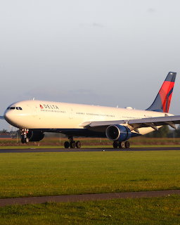 Delta Airbus A330 airplane on a runway with grass in the foreground
