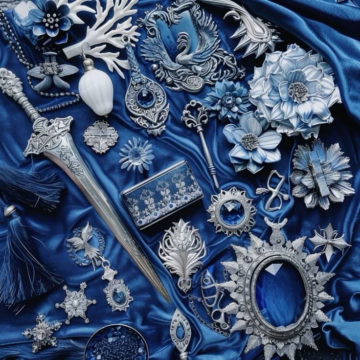 Blue and silver jewelry and decorative ornaments arranged on blue fabric
