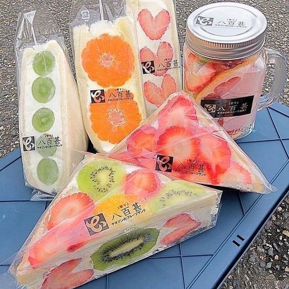 Assortment of Japanese fruit sandwiches with strawberries, kiwi, and oranges in clear packaging
