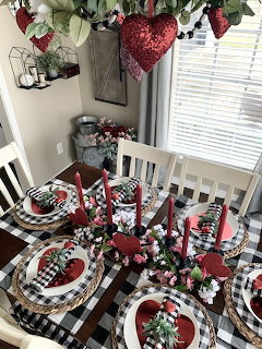 Valentine's Day table with red roses, hearts, candles and dinnerware