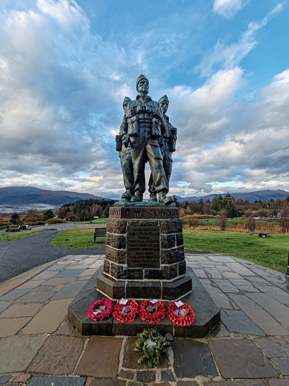 Commando Memorial bronze statue at Spean Bridge, Scotland, with poppy wreaths and Highland hills in background