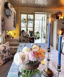 Rustic cottage dining room with flower centerpiece and lake view through windows
