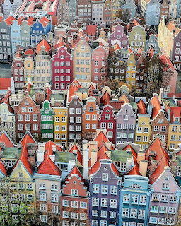 Dense cluster of colorful narrow old-town houses with red roofs