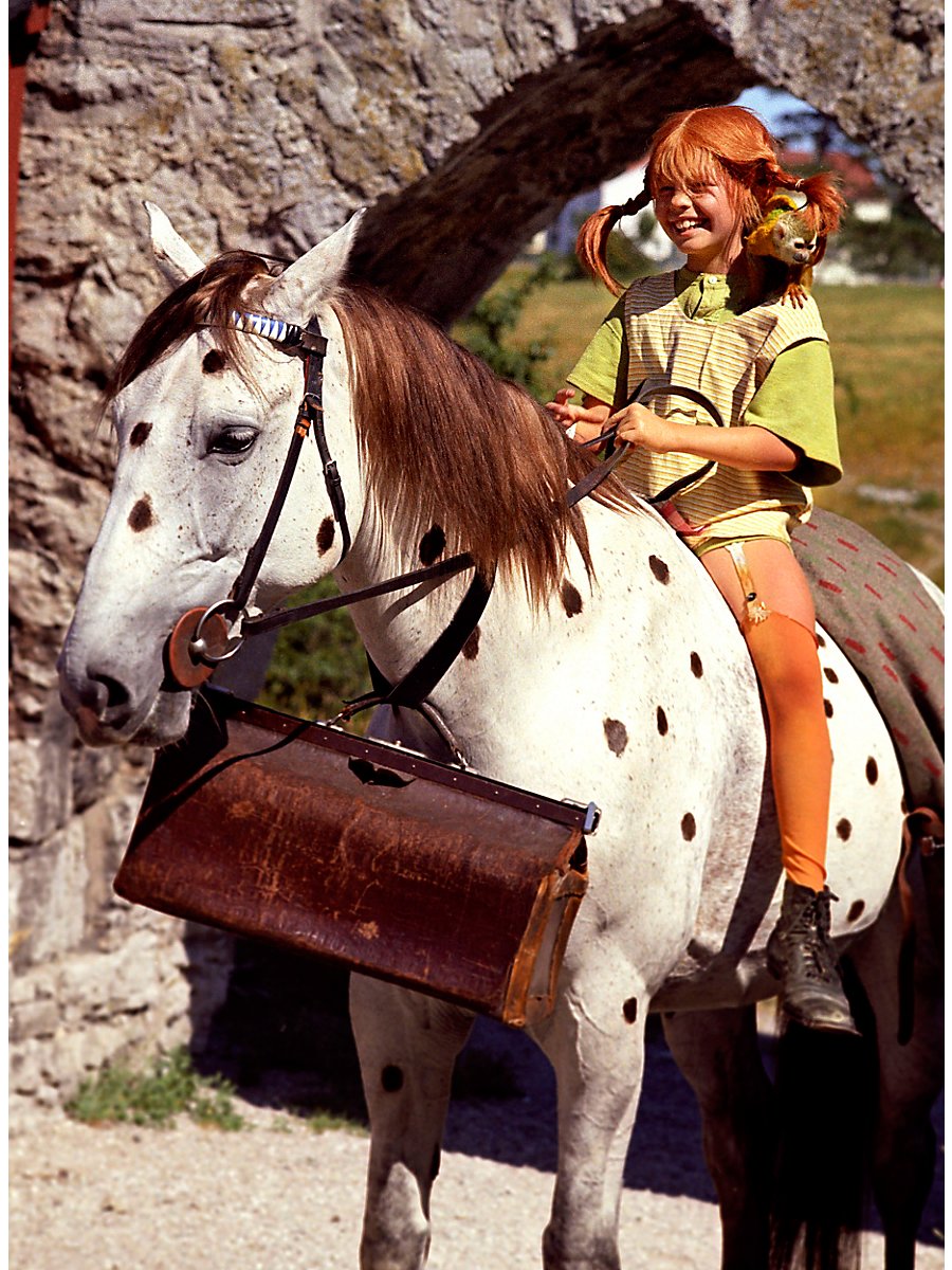 Red-haired girl riding a horse outdoors