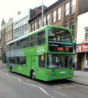 Green Scania double-decker bus number 991 on Nottingham street with brick buildings