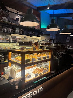 Cafe dessert display with coffee and pastries in cozy aesthetic setting