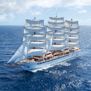 Large white sailing ship with full sails on blue ocean