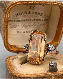 Vintage art deco citrine ring with diamond accents in an open jewelry box