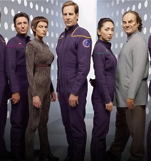 Five Star Trek Enterprise cast members in futuristic uniforms posing together