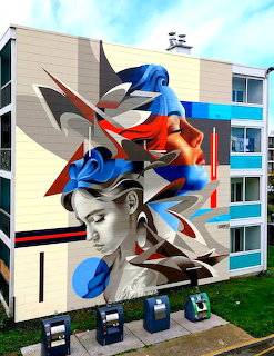 Colorful abstract mural with geometric shapes and portrait fragments on building exterior
