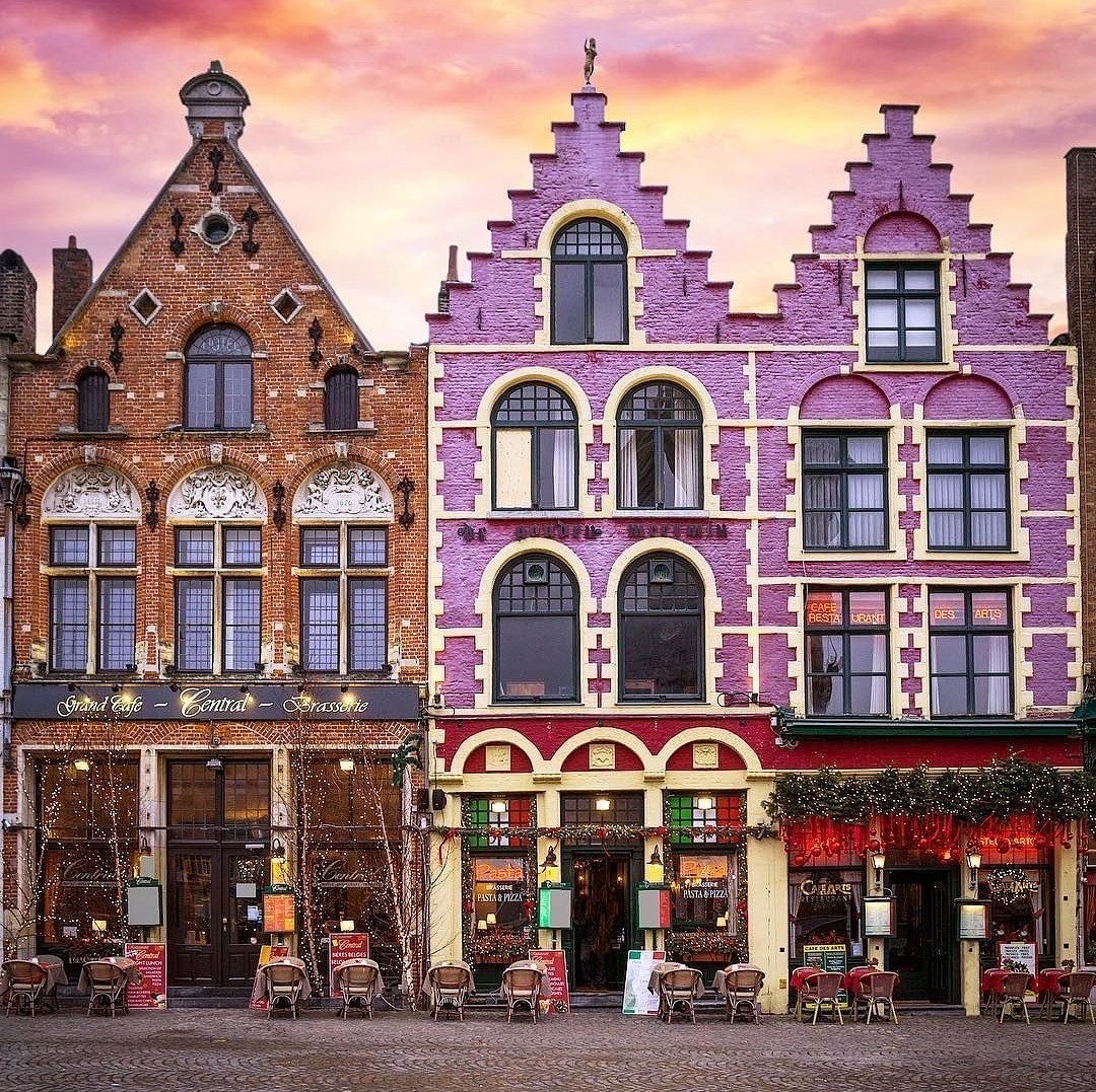 Colorful medieval guild houses with stepped gables in Bruges market square at sunset