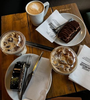 Overhead view of coffee drinks and chocolate desserts on wooden table with latte art and tiramisu cake