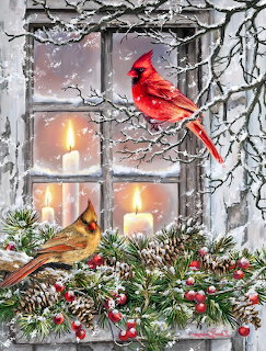 Red and brown cardinal birds on snowy branches outside a window with lit candles and pine cones