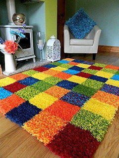 Bright multicolored patchwork shag rug in living room with white chair and wood floor