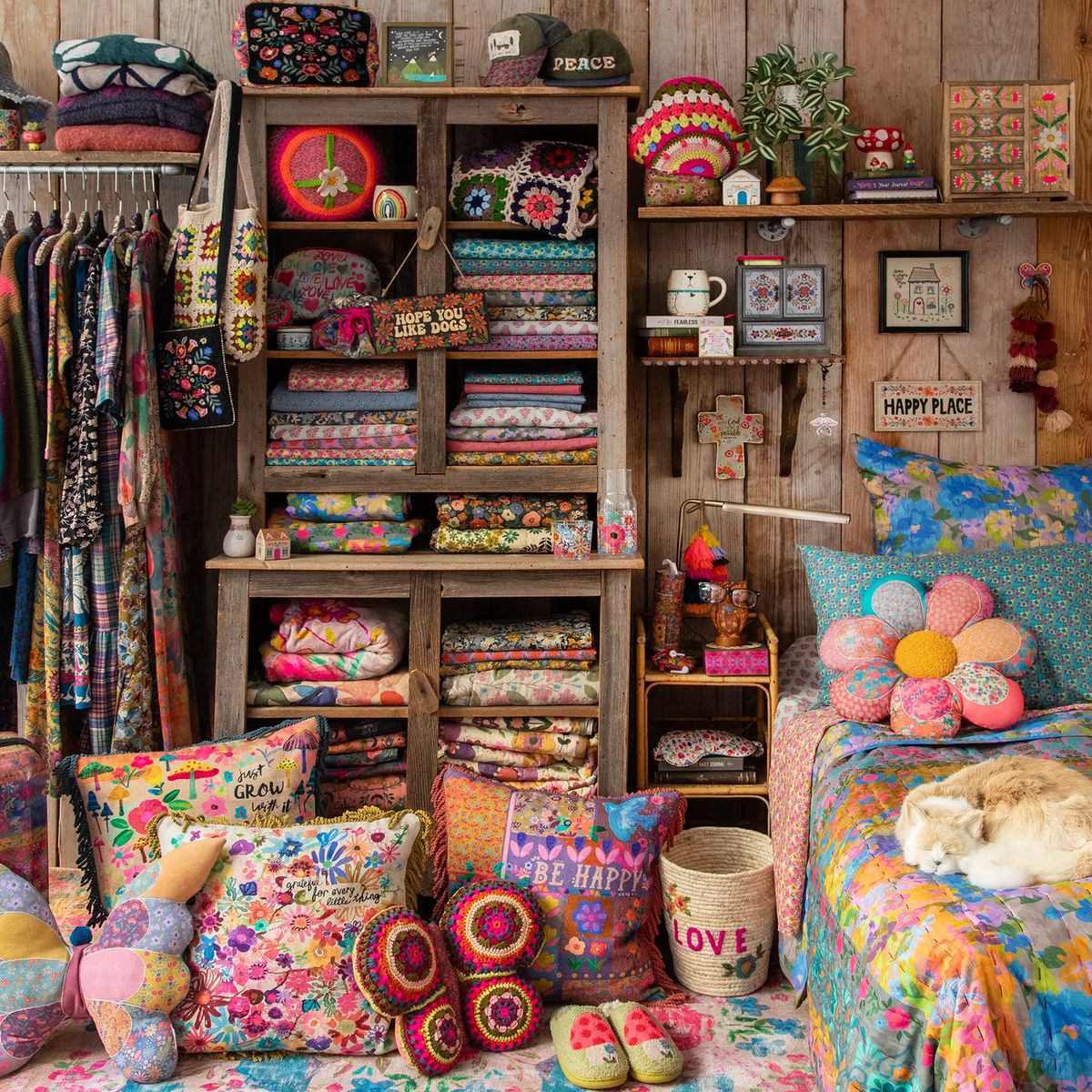 Craft room with colorful quilts, yarn, and handmade textiles on wooden shelves