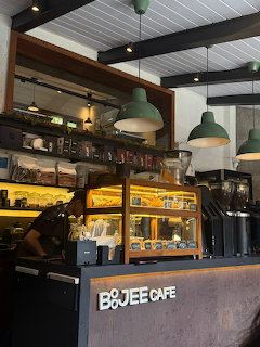 Modern cafe interior with green pendant lights and illuminated bakery display cases
