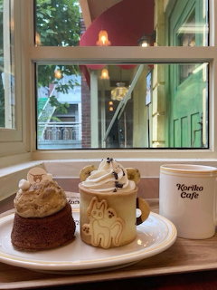 Coffee shop window view with drink and dessert on wooden table