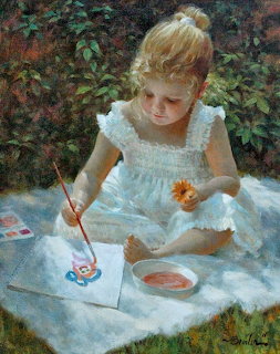 Young girl in white dress painting with watercolors outdoors on grass