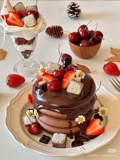 Layered chocolate cake topped with strawberries, cherries, and daisies on a plate with autumn decor