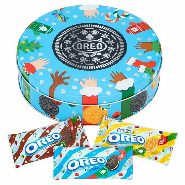 Round blue Oreo cookie tin with holiday patterns and assorted seasonal Oreo cookie packages