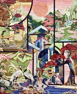 Quilted fabric artwork showing Asian village with pagodas, cherry trees, mountains, and figures in traditional dress