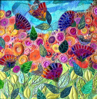 Colorful textile art quilt with embroidered flowers, birds, and leaves in vibrant blues, purples, pinks, and oranges