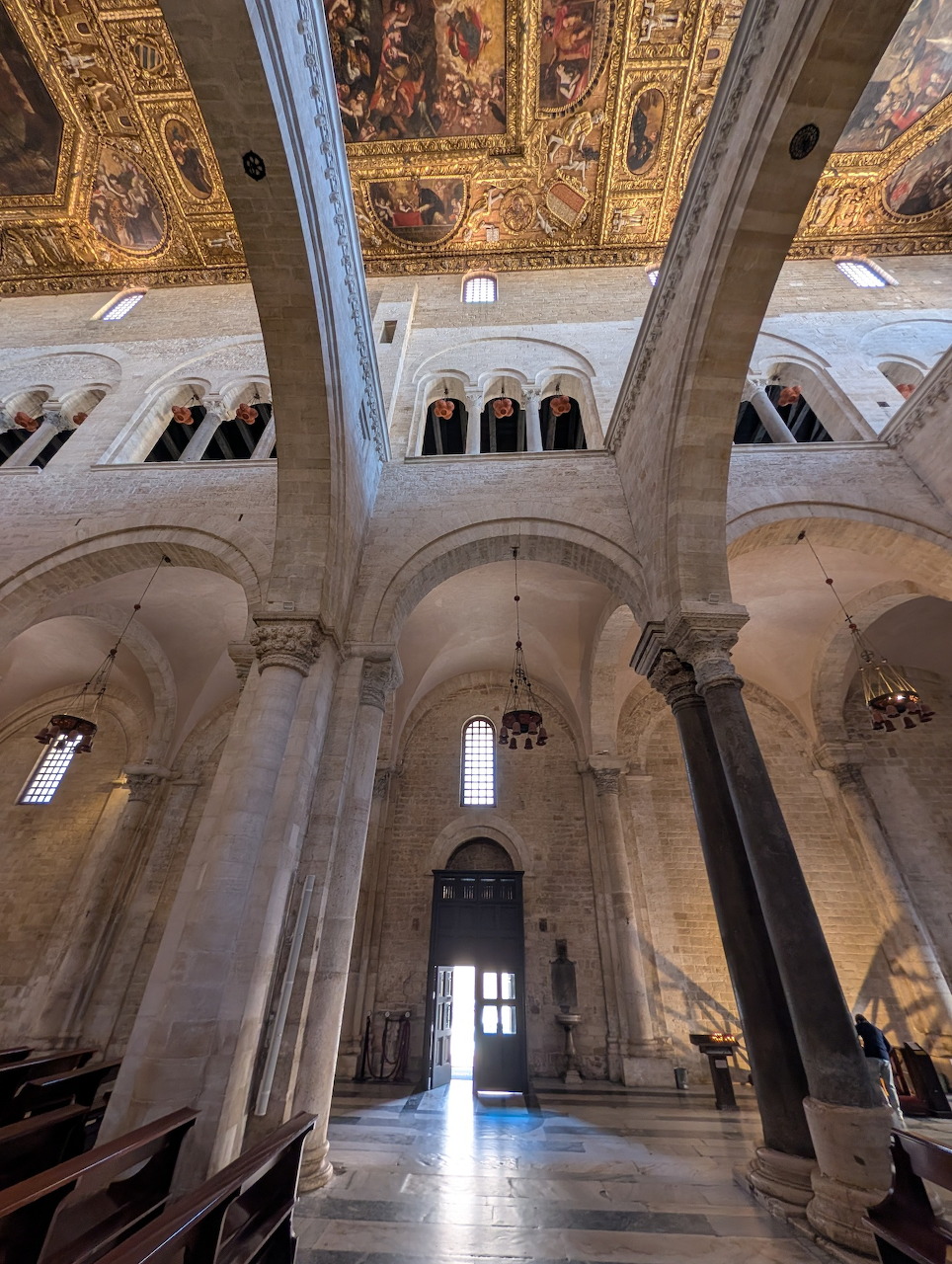 Interior of Basilica di San Nicola showing tall columns, arched ceiling, and ornate golden decorative elements