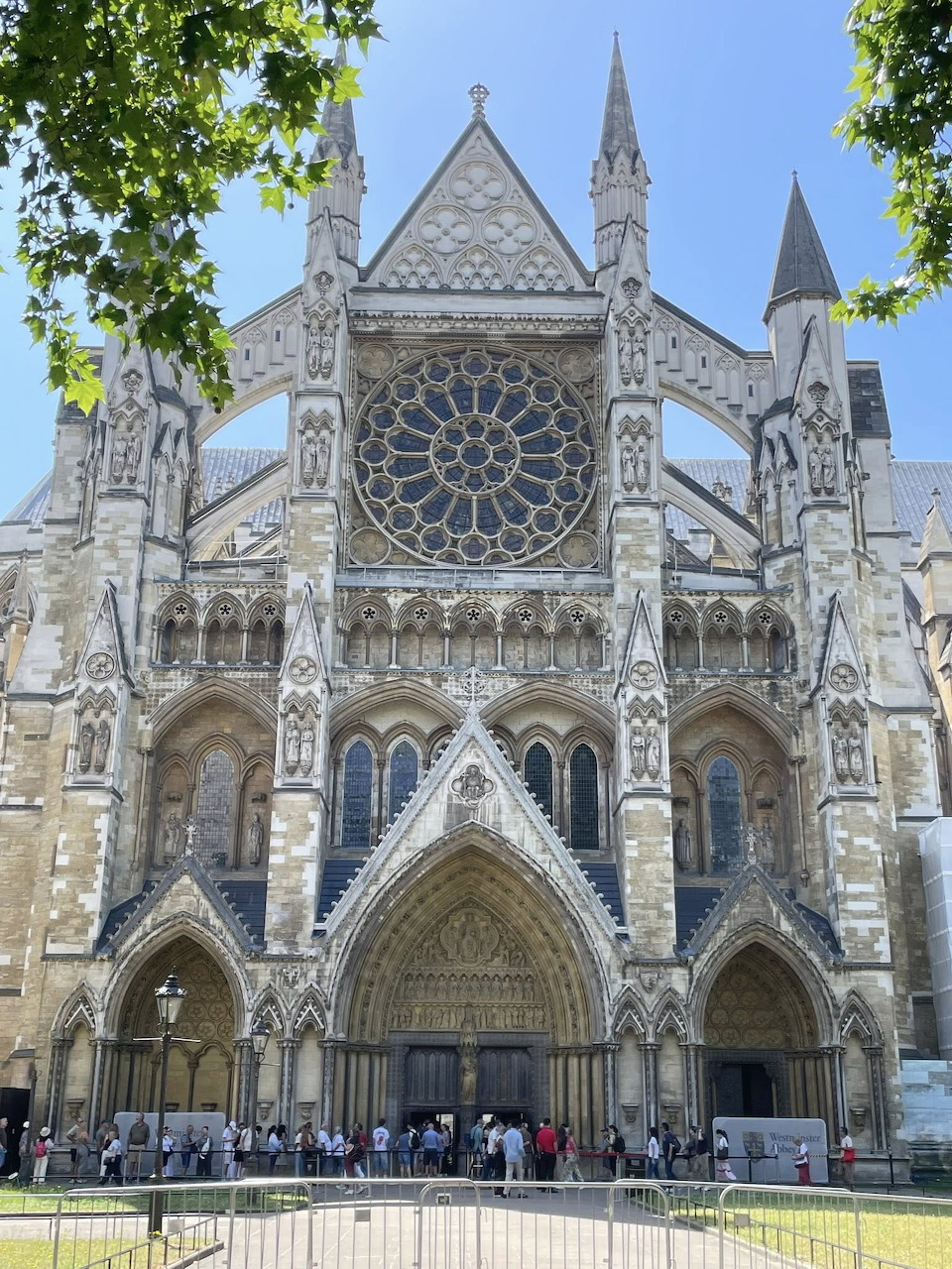 Ornate Gothic facade of Westminster Abbey in London with a large rose window and pointed arches