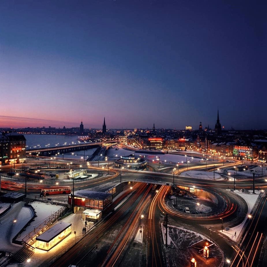Twilight cityscape of Slussen in Stockholm with winding roads, lights, and patches of snow
