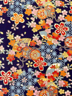 Colorful Japanese fabric with origami flowers and geometric patterns on dark blue background