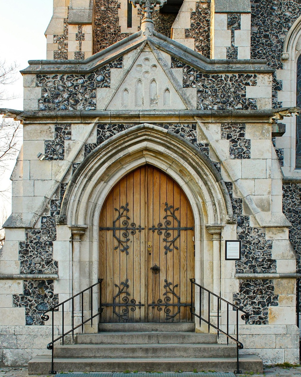 Gothic church entrance with an arched wooden door set in a stone facade