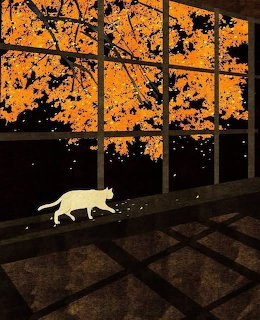 White cat on checkered floor walks past windows showing orange autumn trees at dusk