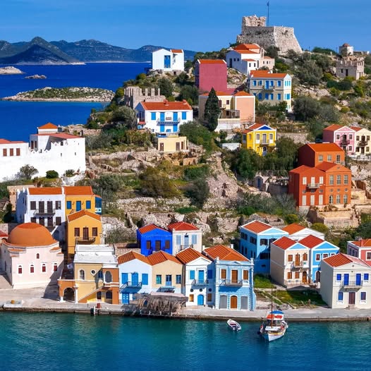 Colorful houses on hillside overlooking turquoise harbor in Greek island village