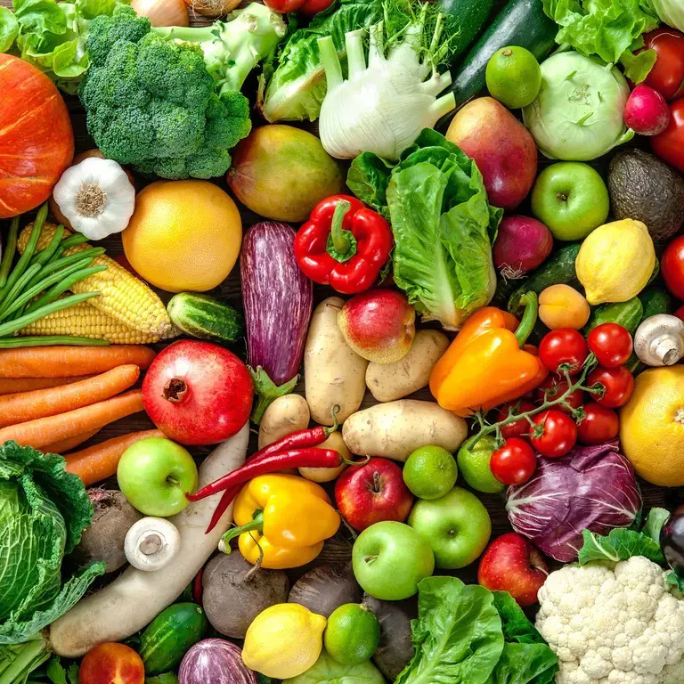 Overhead view of colorful fresh fruits and vegetables arranged together including broccoli, carrots, apples, and tomatoes