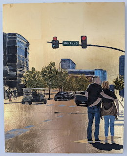 Two people viewing a painting of a city street with buildings and traffic lights