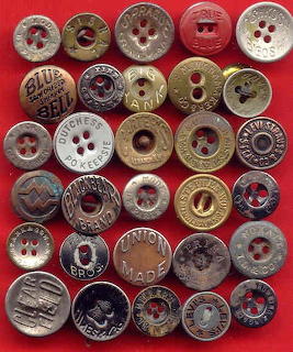 Assorted vintage metal buttons with engraved text and brand logos arranged on a red background