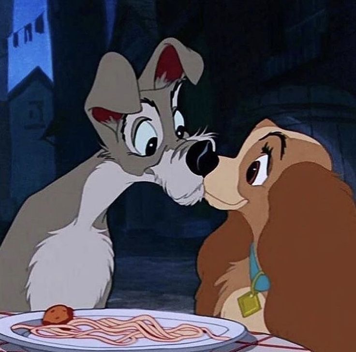 Lady and Tramp cartoon dogs touching noses over a plate of spaghetti at night