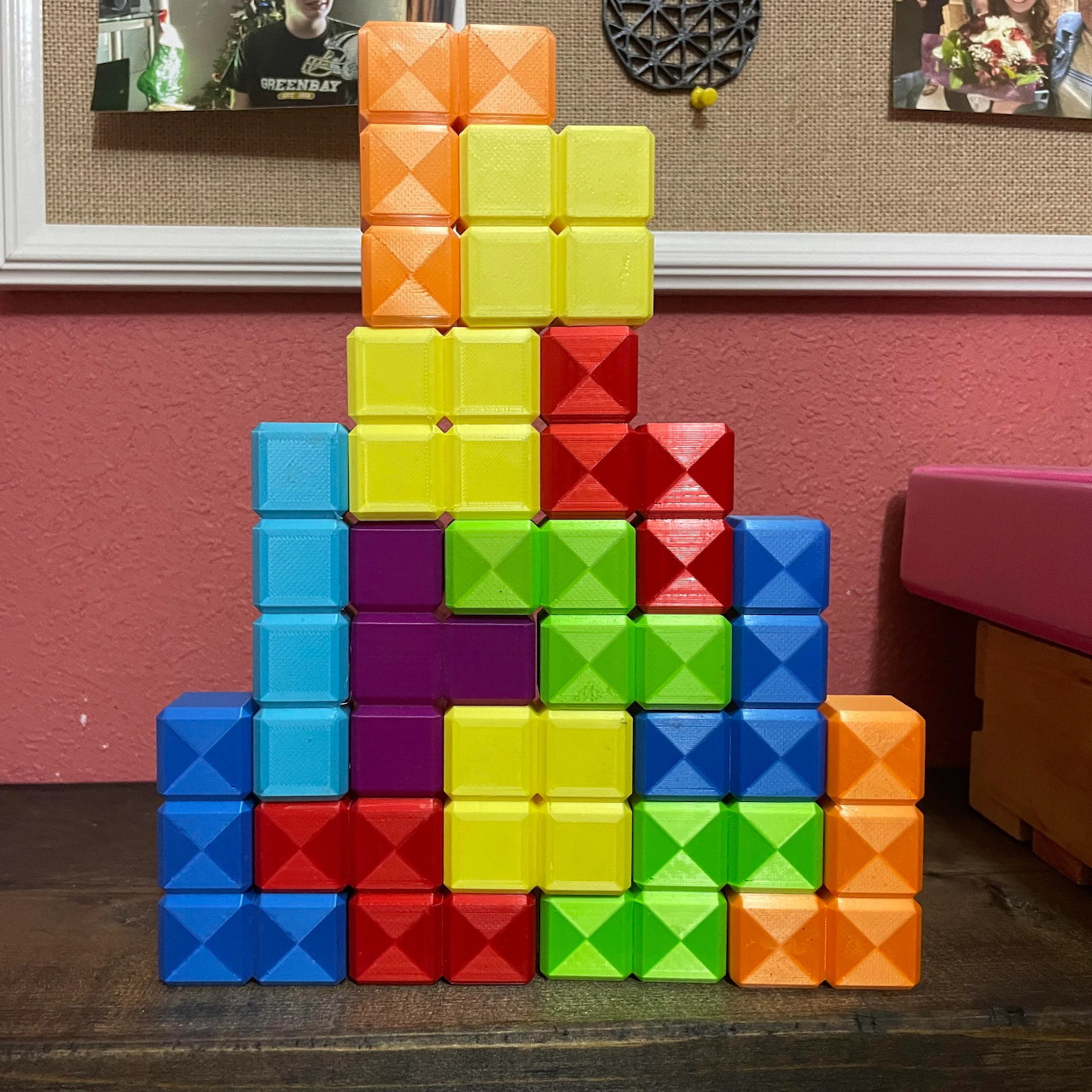 Colorful stacked Tetris blocks forming a pyramid shape on carpet