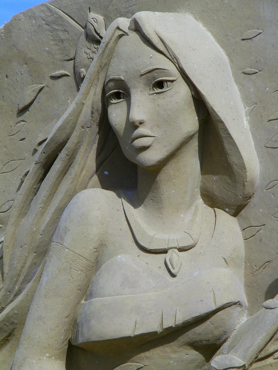 Sand sculpture of angel with wings and veil looking upward