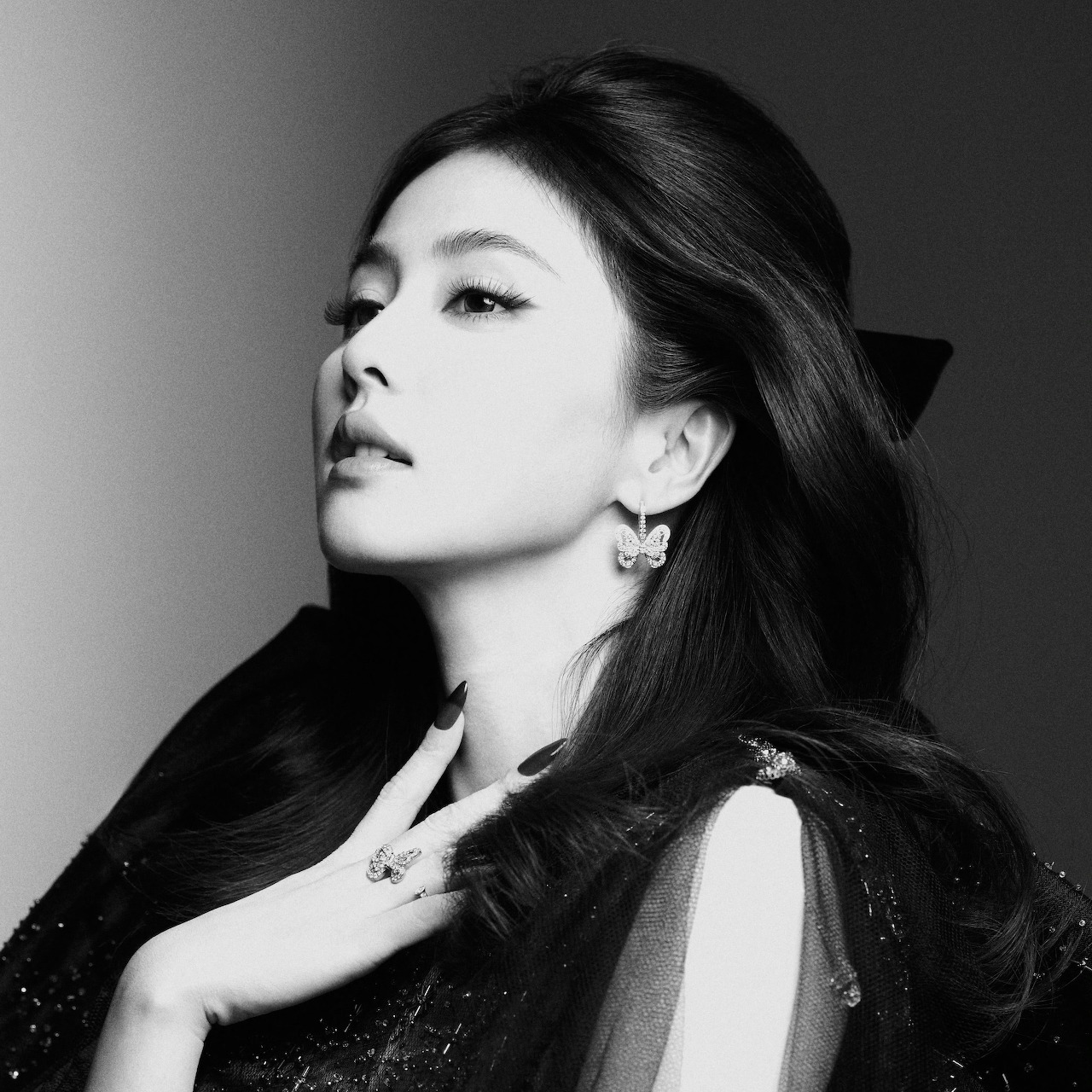 Black and white profile portrait of a woman with long dark hair and earrings