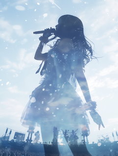 Silhouette of a woman singing into a microphone on stage against a blue sky with light particles