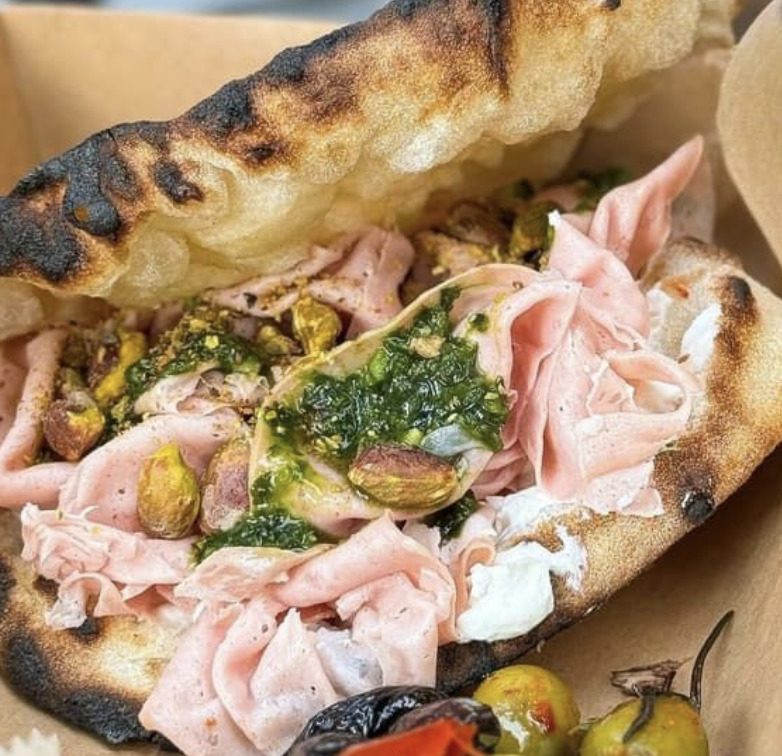 Grilled flatbread sandwich with mortadella, pistachios, cheese, and green sauce